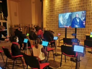 public assis devant l'écran géant du musée numérique de la Micro-Folie de Marines